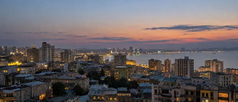 איור AI: אורות העיר באקו מעל המפרץ בערב