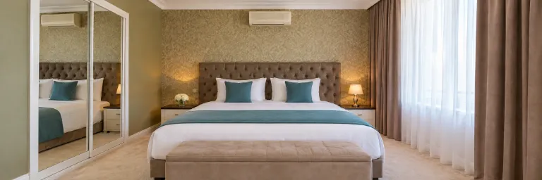 איור AI בהשראת החדר המוצג באתר הרשמי של Astoria Hotel Baku: מיטה לבנה, ראש מיטה כהה מרופד בכפתורים, כריות וראנר טורקיז, ספסל בז׳, קיר מעוצב בגוני זית, ארון מראות ווילונות ליד חלון